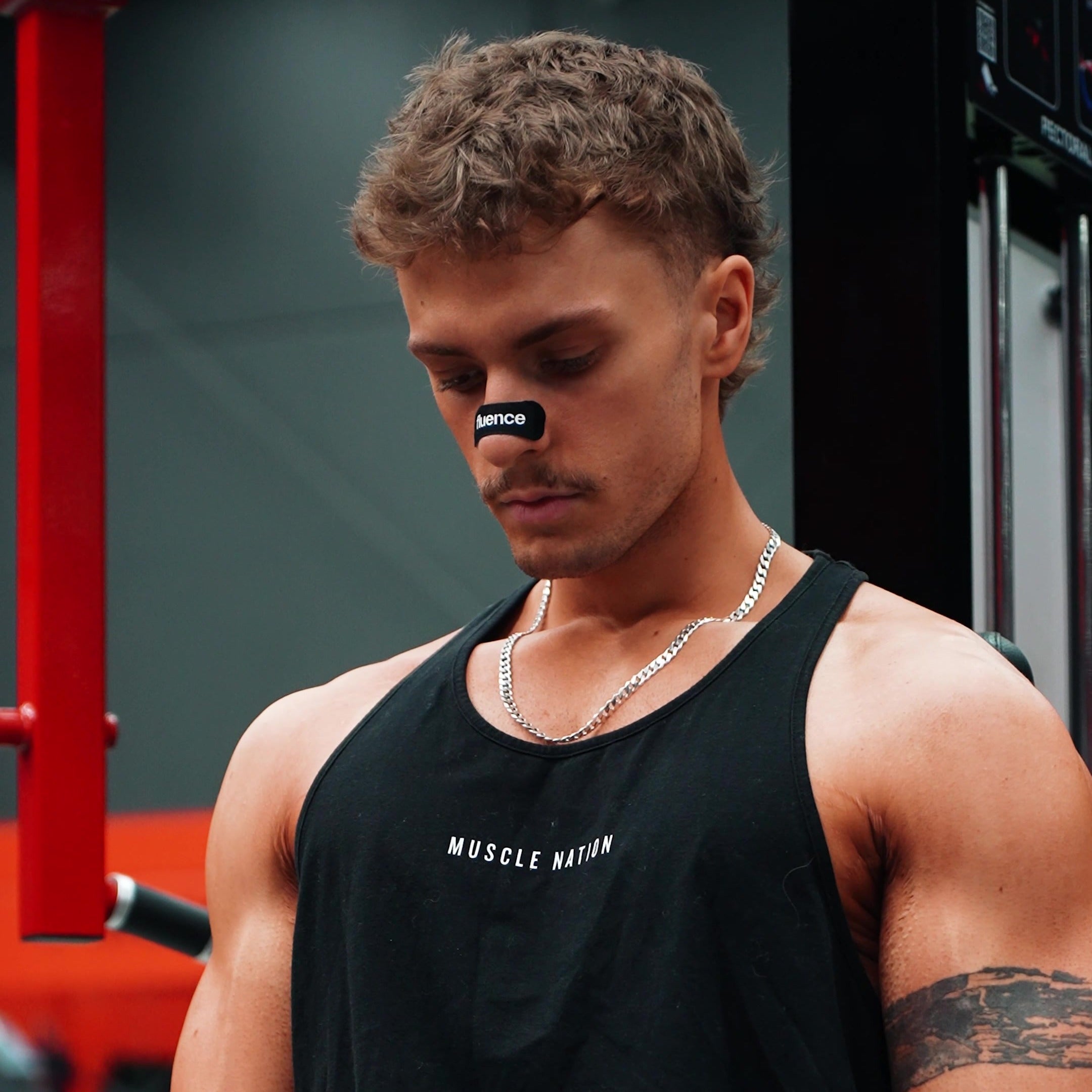 A Fluence nasal strip worn across the bridge of the nose in the gym
