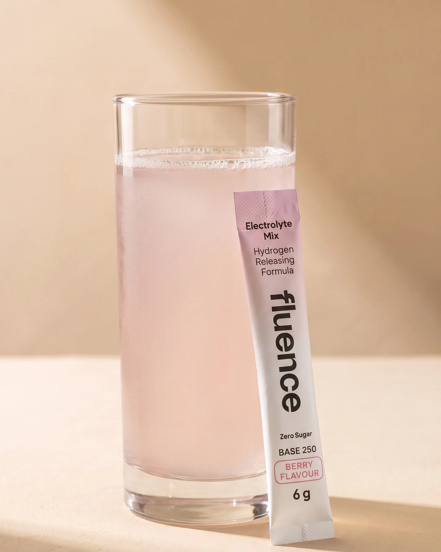 A glass of Base 250 Berry made up, beside a Berry sachet