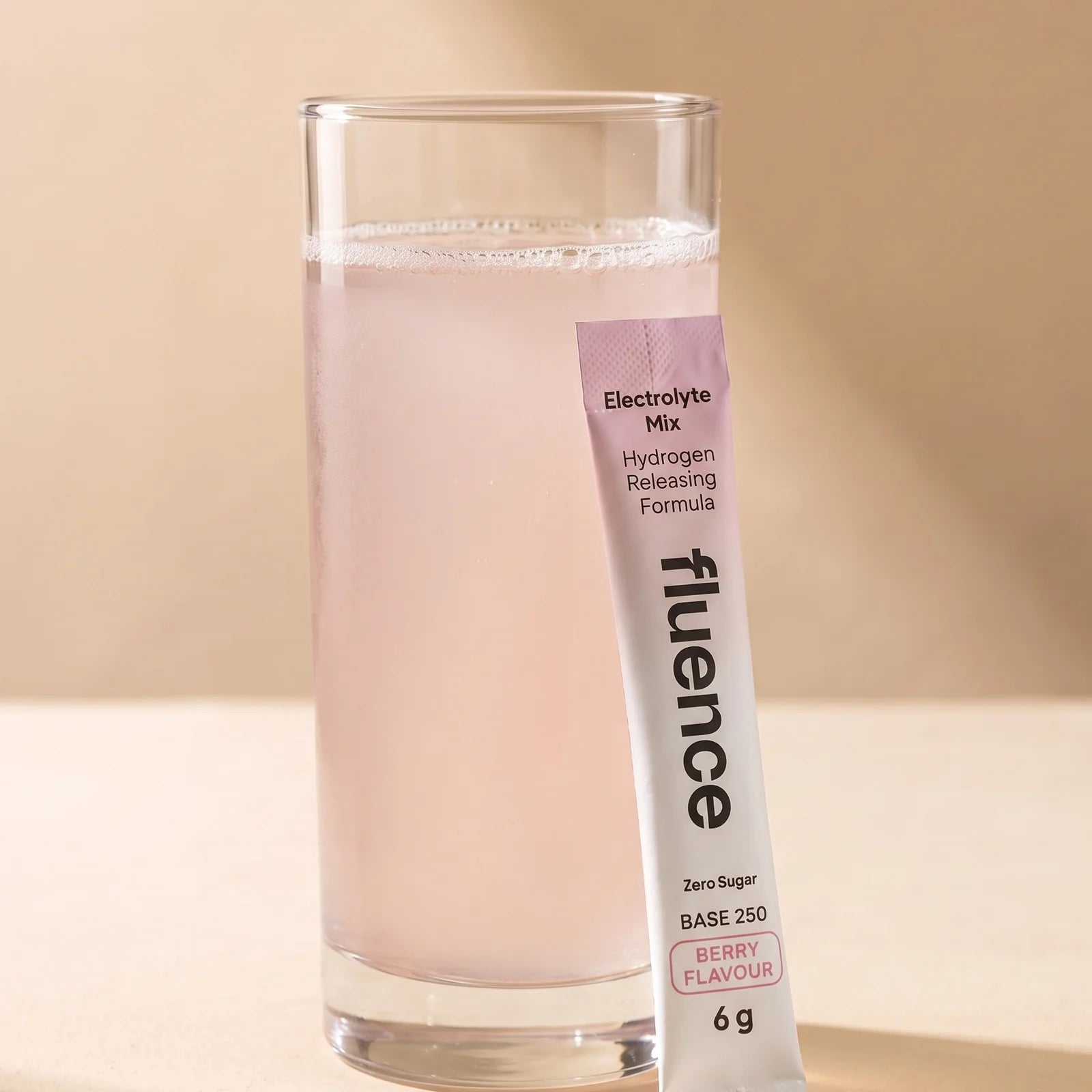 A glass of Base 250 Berry beside a Berry sachet