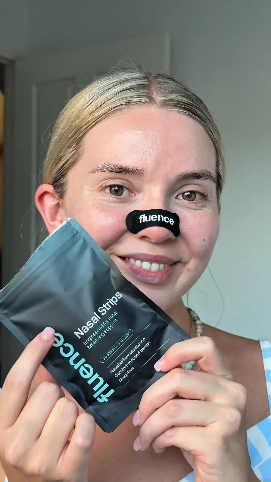 A Fluence nasal strip worn across the bridge of the nose, beside the pack